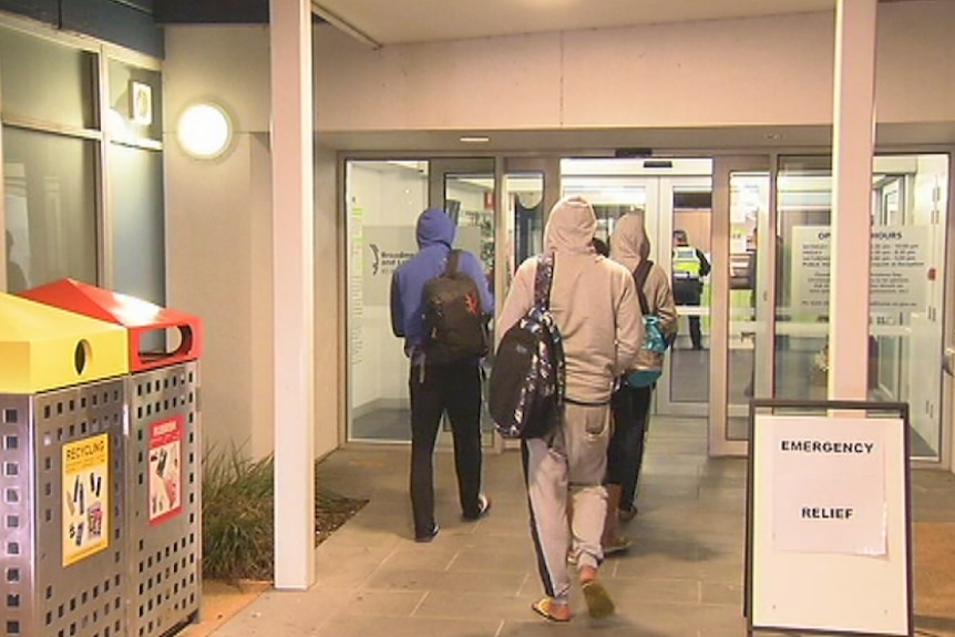 A group of people walks into a relief centre.