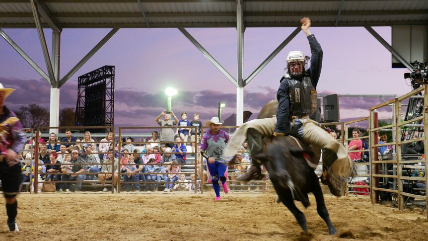 an action shot of a bullriding competition