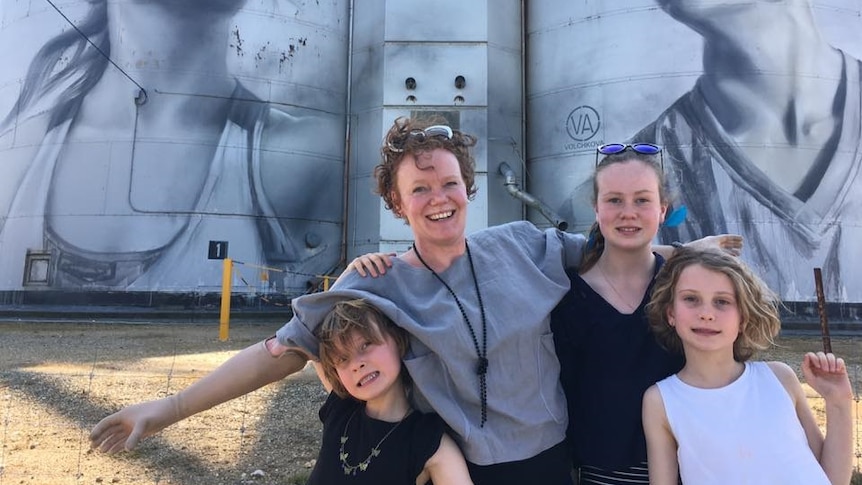 A family in front of silo art.