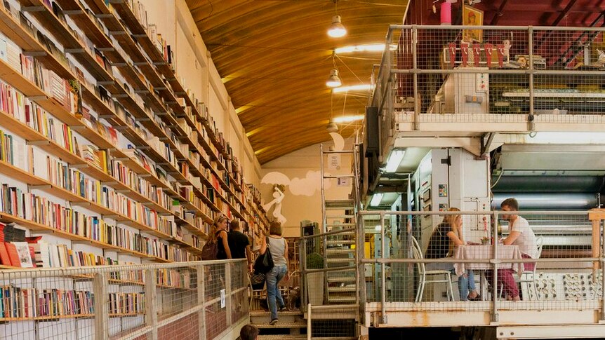 A book store with high bookshelves and a printing press
