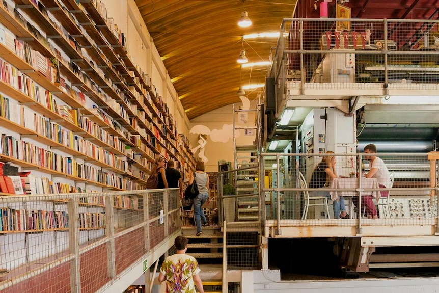 A book store with high bookshelves and a printing press