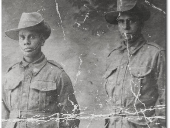 Two Aboriginal soldiers from WWI stare solemnly into the camera.
