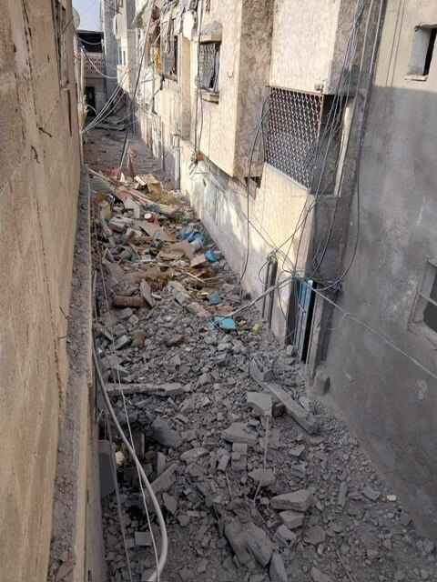 A photo of rubble filled alleyway in Gaza.