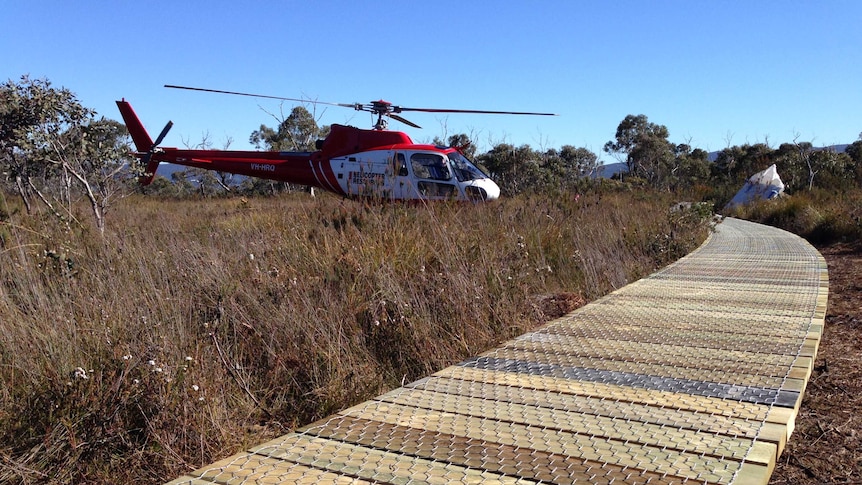 A helicopter lands near a worksite on Tasmania's Three Capes track on Tasman Peninsula.