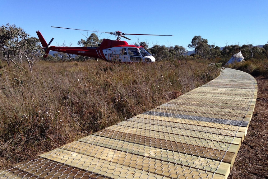 A helicopter lands near a worksite on Tasmania's Three Capes track on Tasman Peninsula.