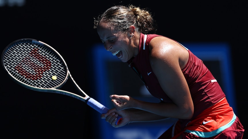 A female tennis player pumps her fists as she celebrates match point at the Australian Open.