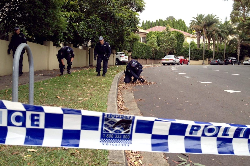 Police search Bella Vista street for bullet casings.