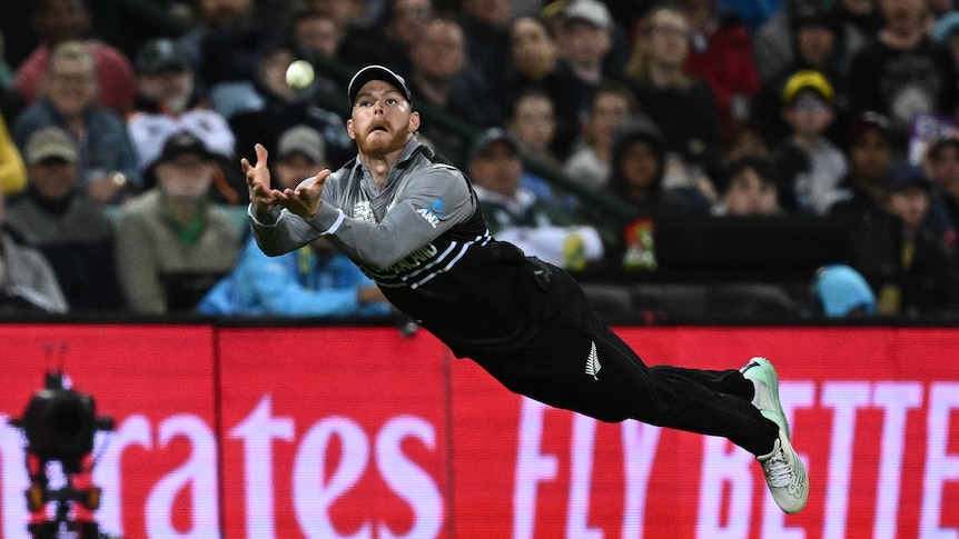 Glen Phillips dives forward looking at a ball with his hands in front of him ready to take the catch