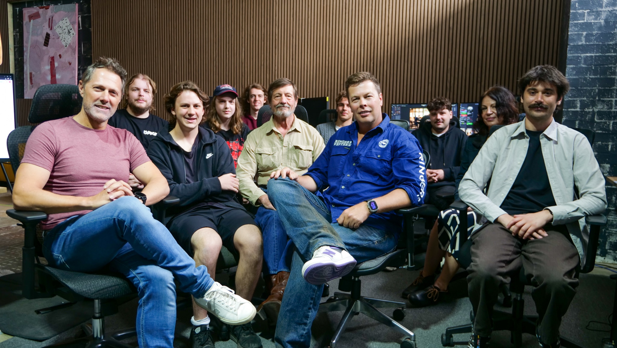 Una sala llena de gente sentada en sillas frente a sus lugares de trabajo. 