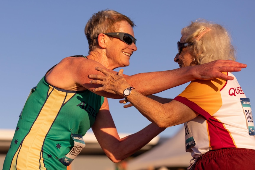 Christiane Dauphinet, 91, hugs women's 65-70 competitor Gillian Hayden after a race.