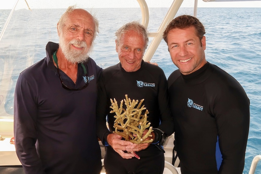 Dr Charlie Veron holding a sample of the new species, with John Rumney and Dr Dean Miller of GBR Legacy on a boat