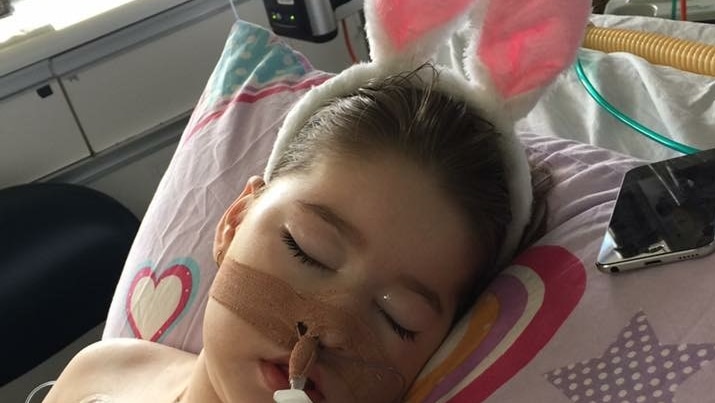 Sophie Martin lying asleep in a hospital bed wearing bunny ears