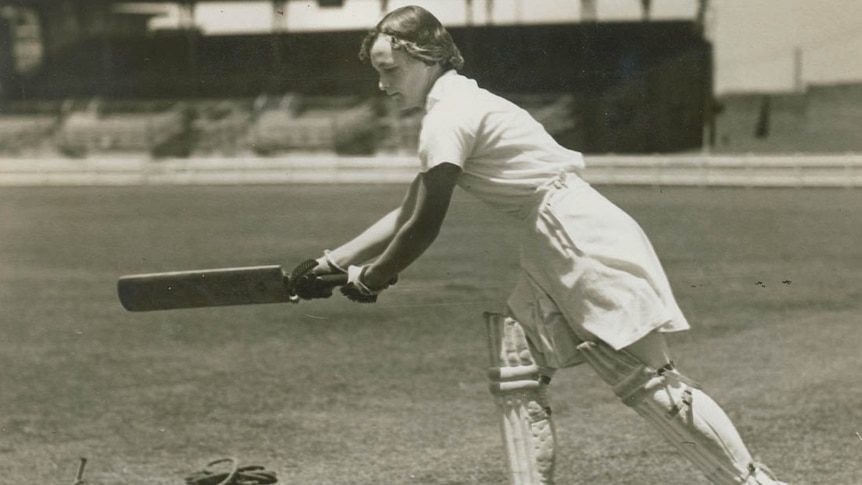 A black and white photograph of Mary Spear holding a bat.
