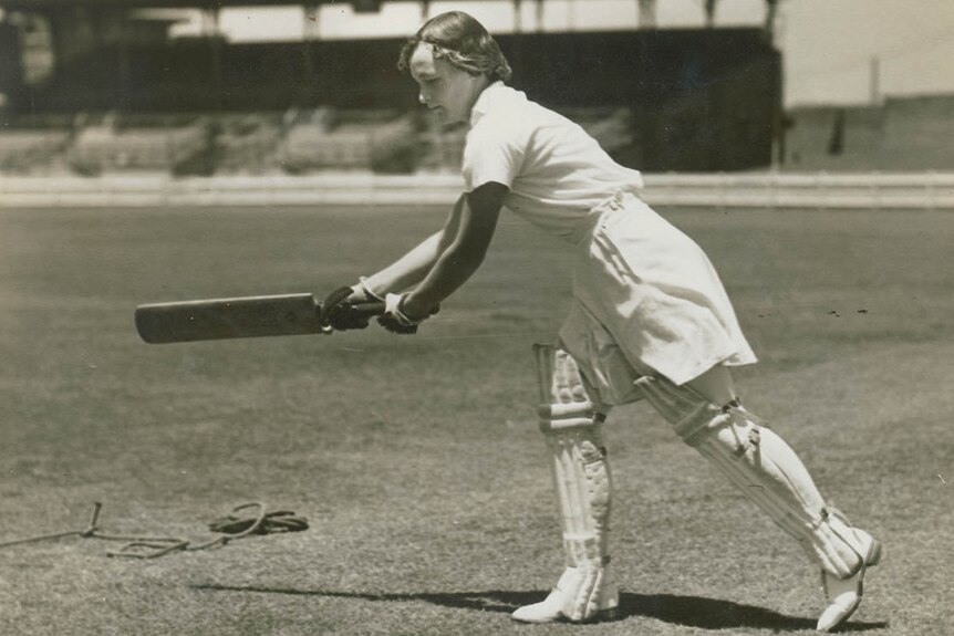 A black and white photograph of Mary Spear holding a bat.