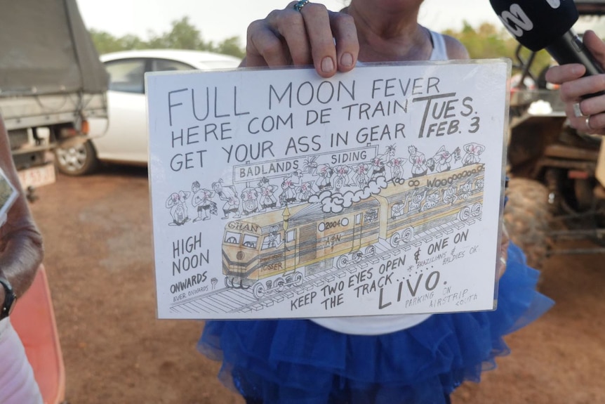 Someone holding up the original poster for the inaugural Ghan mooning in 2004.