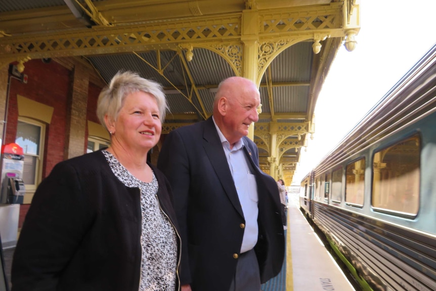 Tim Fischer with his wife, Judy Brewer stand on a railway platform at the Albury Railway Station, 2019.