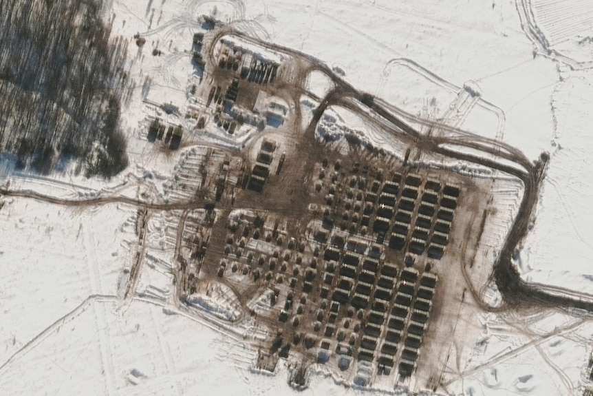 A satellite image shows troop housing area and tents.