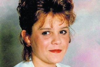 A smiling young woman with short hair poses for a formal photograph.