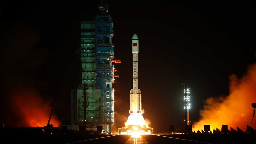 China's Tiangong-1 lifts off on a rocket from a launch pad.