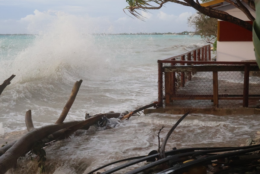 A wave crashes and water floods the balcony of a house in Funafuti, Tuvalu. 