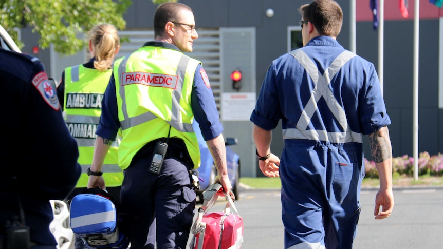 Two Victoria Ambulance paramedics walk away from camera at the Melbourne Youth Justice Centre