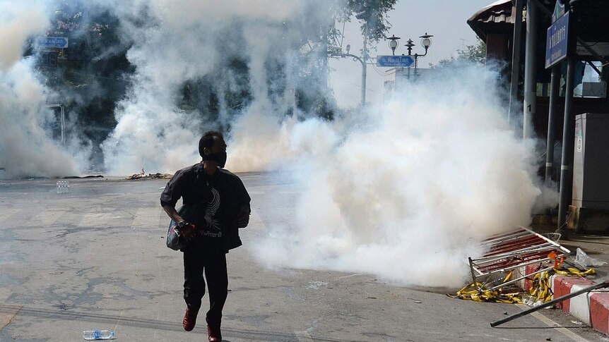 Thai anti-government protester runs as police fire tear gas shells