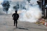 Thai anti-government protester runs as police fire tear gas shells