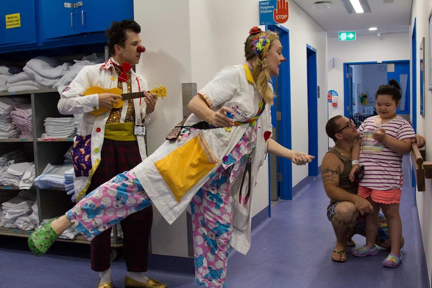 Clown doctors entertain a patient in the hall of the children's hospital in Randwick