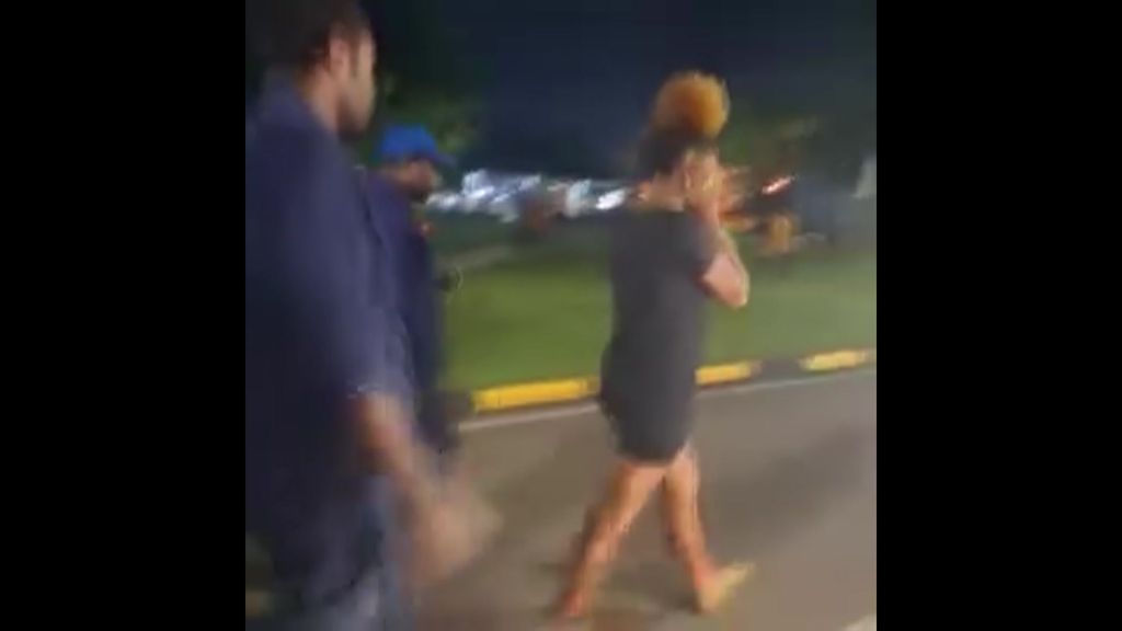Screengrab of mobile video shows woman with her hands over her ears being followed by men.
