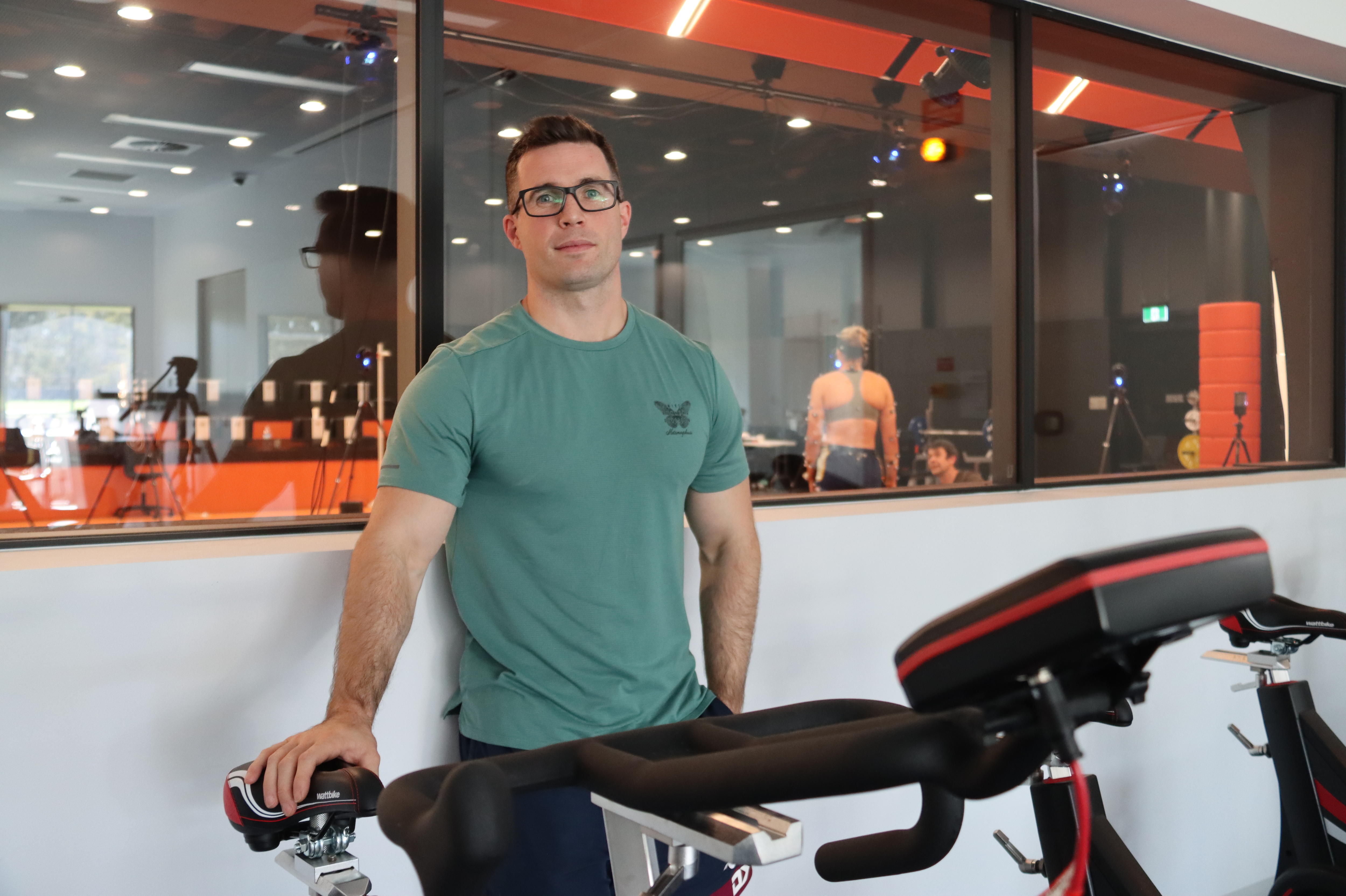 Un científico del deporte junto a una cinta de correr en un laboratorio de pruebas.