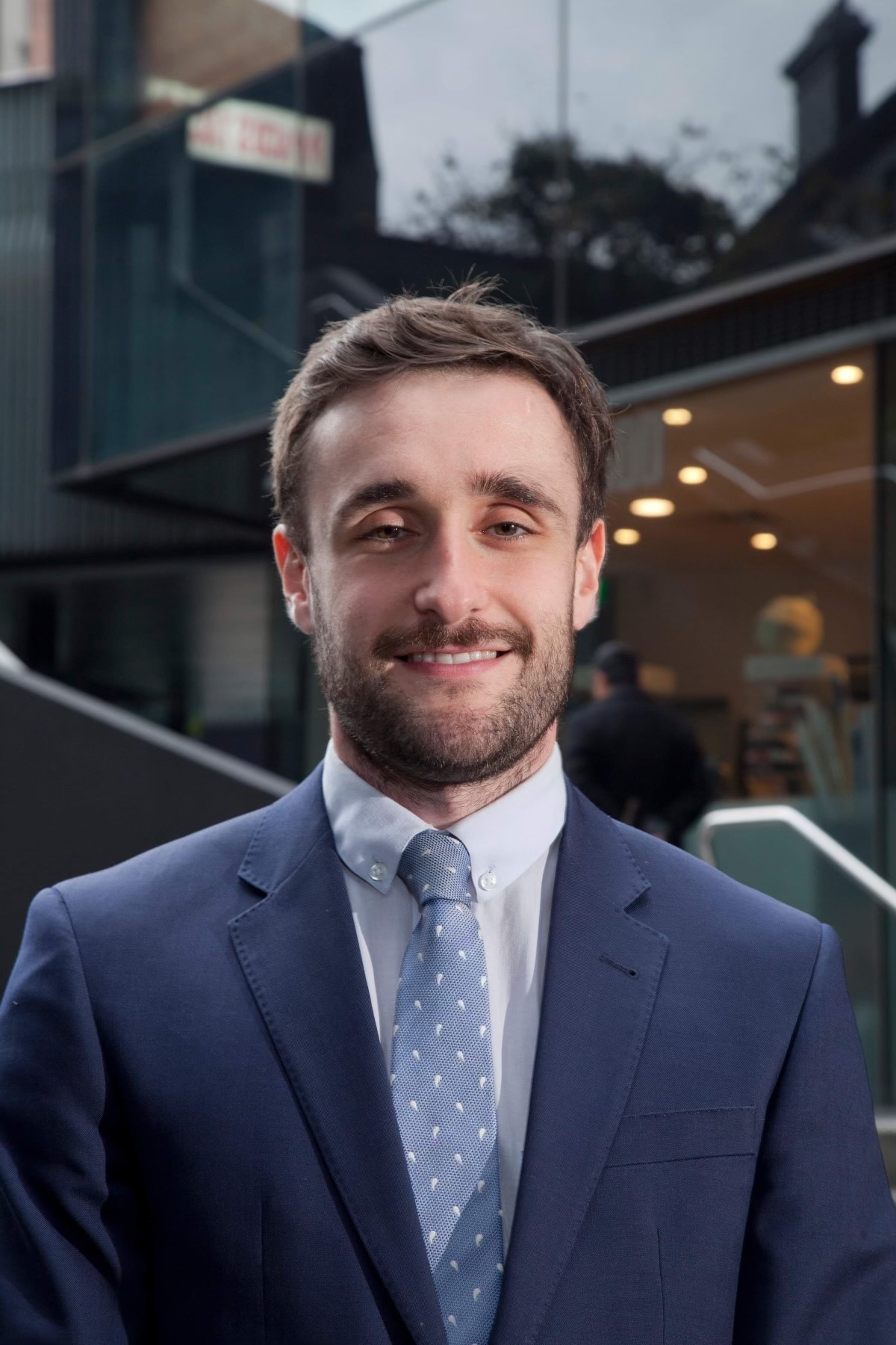 A portrait of Matthew Martin, legal director at Mortgage Stress Victoria. He is smiling and wearing a navy suit and tie.