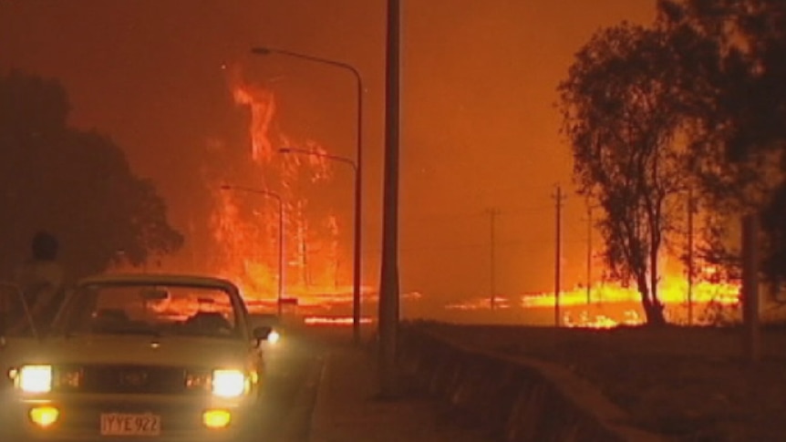 Huge flames lit the darkened sky as a bushfire rushes through Duffy.