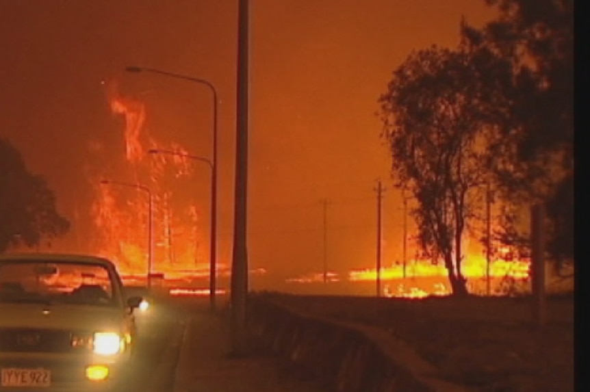 Video still: Huge flames light the darkened sky as the Canberra bushfire rushes  through Duffy on 18 Jan 2003.
