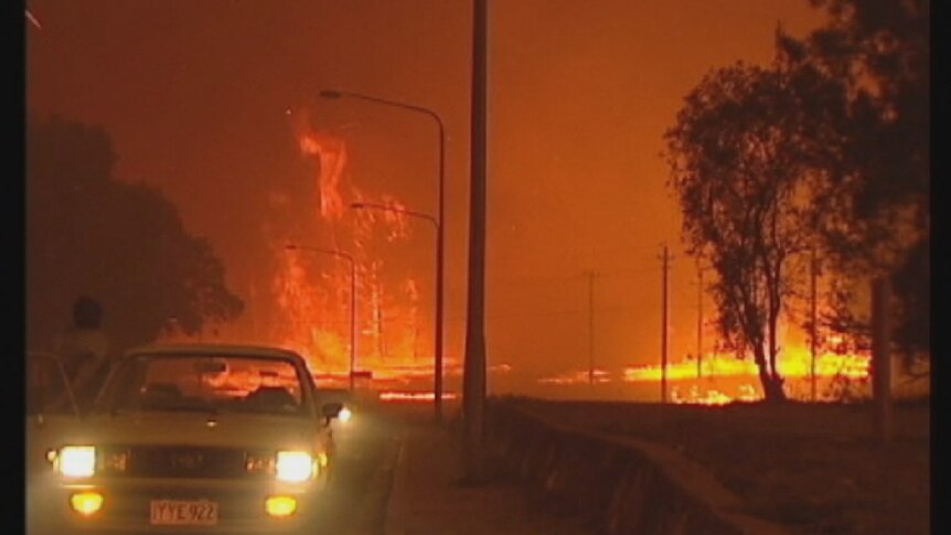 Huge flames light the darkened sky as the Canberra bushfire rushes through Duffy in 2003