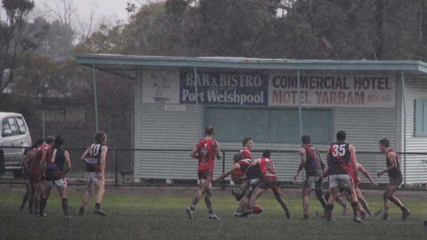 Yarram and Traralgon Tyers united footballers clash in the mud.