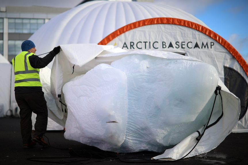 A worker unveils an iceberg.
