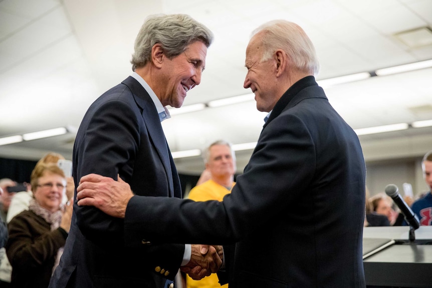 John Kerry and Joe Biden shake hands.