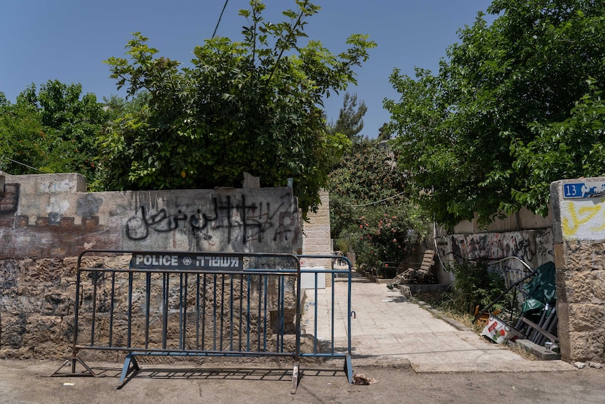 A stone wall fenced off with a police blockade 