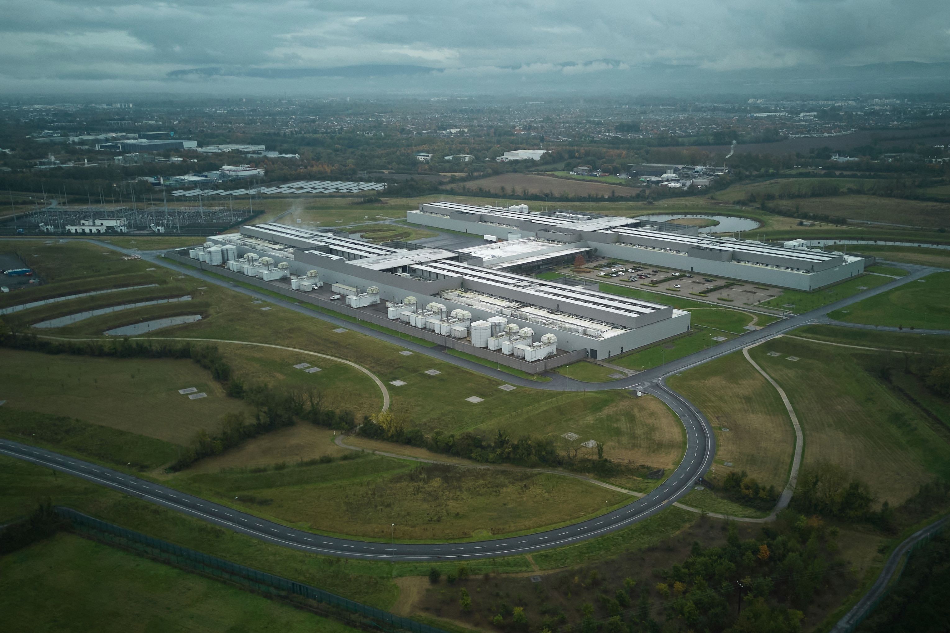 Aerial view of a major industrial facility on the outskirts of a city. 