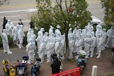 Workers in protective suits prepare for administering coronavirus tests at Shanghai Airport