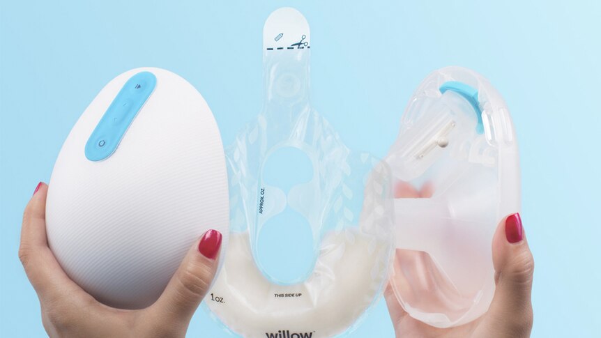 A woman holds up the new Willow breast pump.