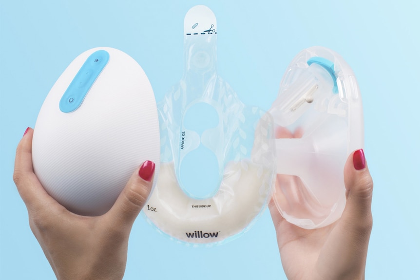 A woman holds up the new Willow breast pump.