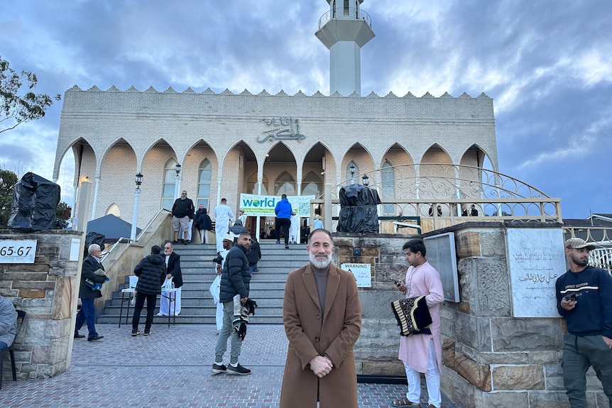 Lakemba Mosque secretary Gamel Kheir stands outside of Lakemba Mosque in a dark brown turtleneck and light brown coat.