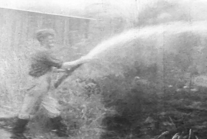 B&W TV still man fighting fire with hose