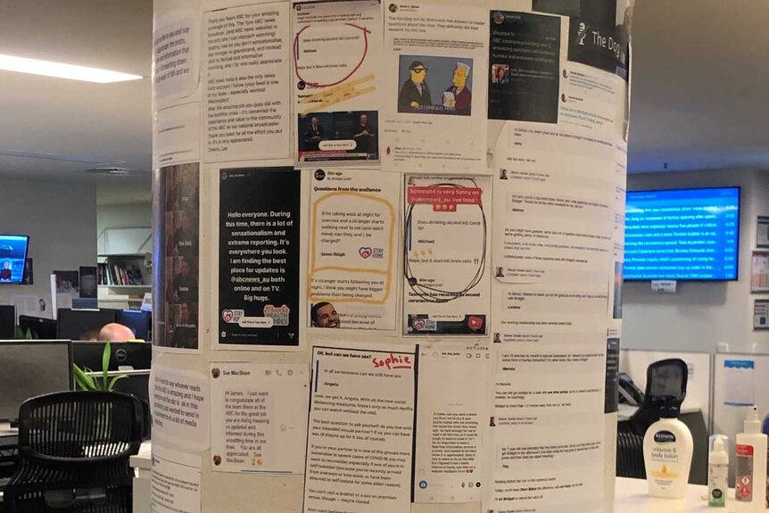 Pole in newsroom with page of posts stuck to it.
