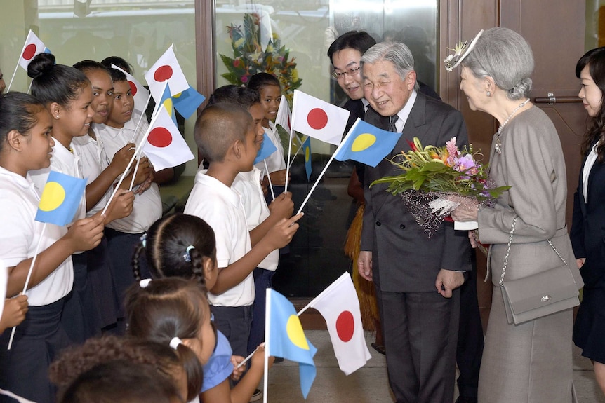 Japanese Emperor Akihito and Empress Michiko are greeted by Palauan children in Koror