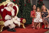 santa and a family in a photograph maintaining physical distance