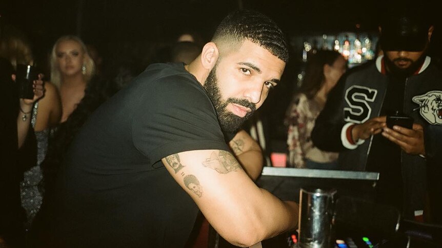 A 2018 shot of Drake leaning on a bar