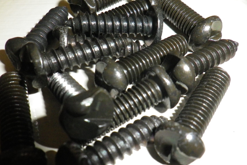 A pile of ant-theft screws on a white background