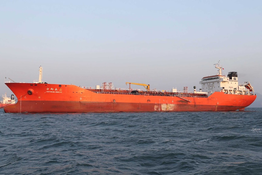 The orange Lighthouse Winmore ship floats in the ocean.